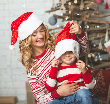 Portrait of happy mother and son on the background of the Christmas tree in new year room. The idea for postcardsの写真素材