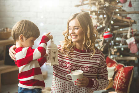 Portrait of happy mother and son on the background of the Christmas tree in new year room. The idea for postcardsの写真素材