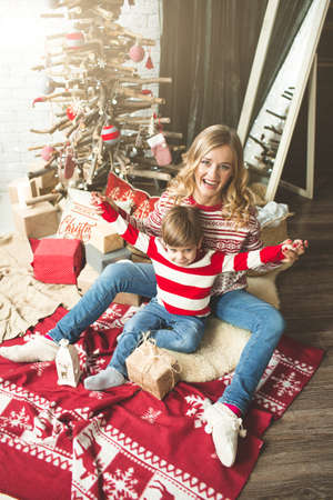 Portrait of happy mother and son on the background of the Christmas tree in new year room. The idea for postcardsの写真素材