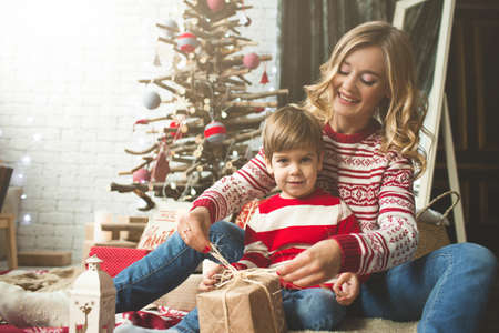 Portrait of happy mother and son on the background of the Christmas tree in new year room. The idea for postcardsの写真素材