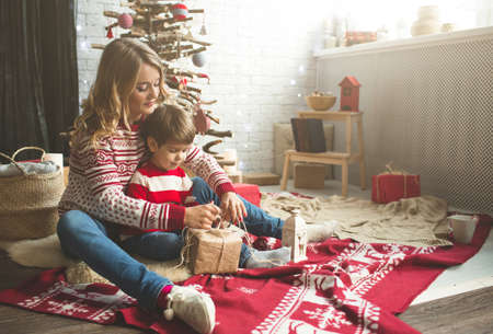 Portrait of happy mother and son on the background of the Christmas tree in new year room. The idea for postcardsの写真素材