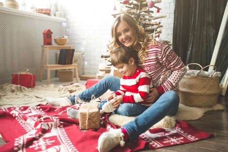 Portrait of happy mother and son on the background of the Christmas tree in new year room. The idea for postcardsの写真素材