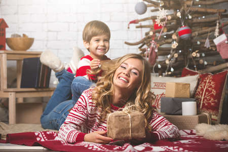 Portrait of happy mother and son on the background of the Christmas tree in new year room. The idea for postcardsの写真素材