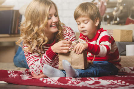 Portrait of happy mother and son on the background of the Christmas tree in new year room. The idea for postcardsの写真素材