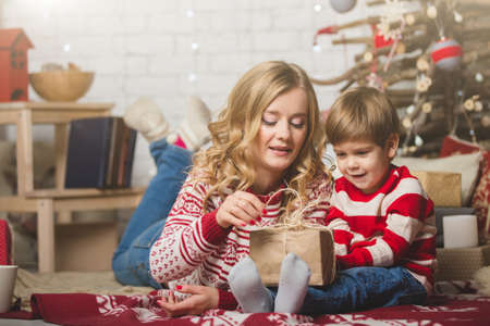 Portrait of happy mother and son on the background of the Christmas tree in new year room. The idea for postcardsの写真素材