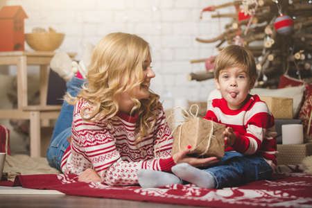 Portrait of happy mother and son on the background of the Christmas tree in new year room. The idea for postcardsの写真素材