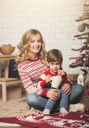 Portrait of happy mother and son on the background of the Christmas tree in new year room. The idea for postcardsの写真素材