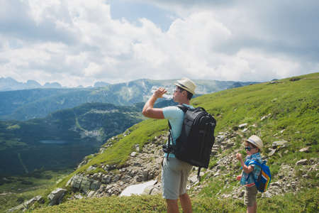 Father and son traveling in Rila mountains Bulgariaの写真素材