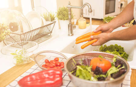 Man washing carrots before eatingの写真素材
