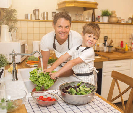 Man and boy washing vegetables before eatingの写真素材