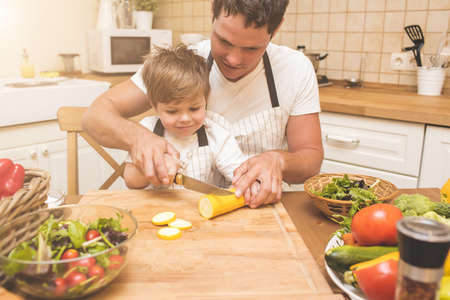 Father is cooking with his sonの写真素材