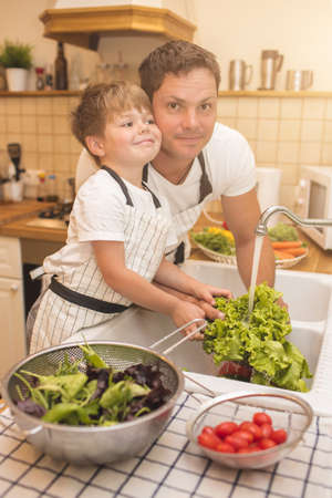 Man and boy washing vegetables before eatingの写真素材