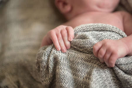 The childs hands hold a knitted blanketの写真素材