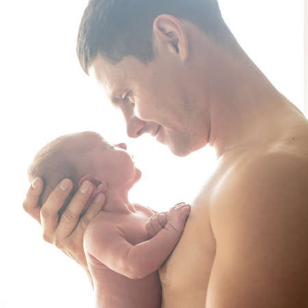 Beautiful dad with his son in his armsの写真素材