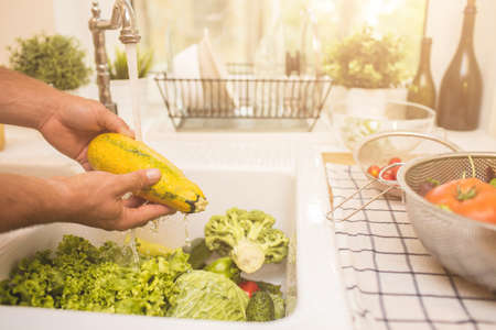 Man washing vegetables before eatingの写真素材