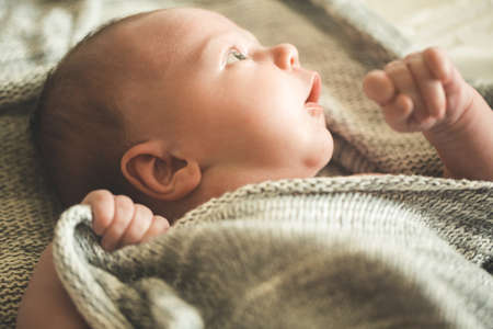 The childs hands hold a knitted blanketの写真素材