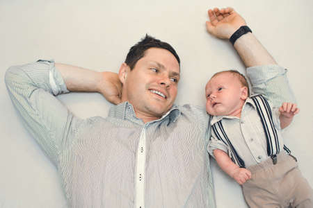 newborn baby dressed like gentleman with his daddyの写真素材