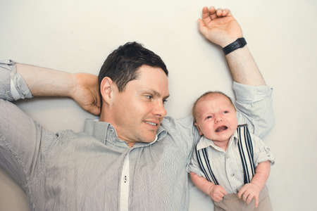 newborn baby dressed like gentleman with his daddyの写真素材