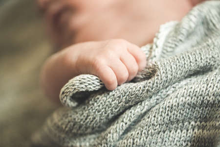 The childs hands hold a knitted blanketの写真素材