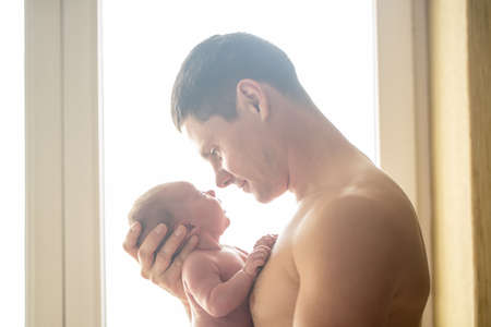 Beautiful dad with his son in his armsの写真素材