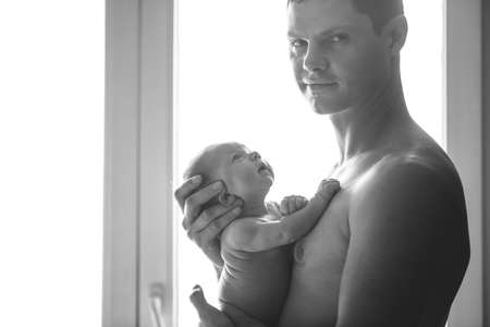 Beautiful dad with his son in his armsの写真素材