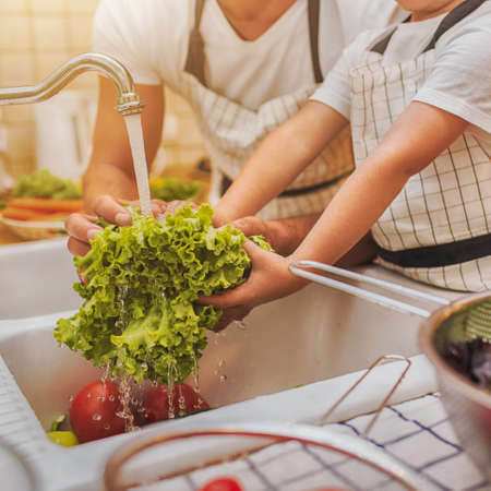 Father with son washes vegetables before eatingの写真素材