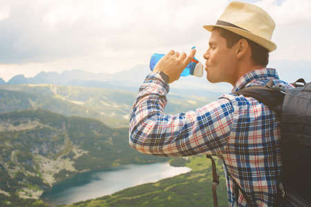 Traveler drinks water in the mountainsの写真素材