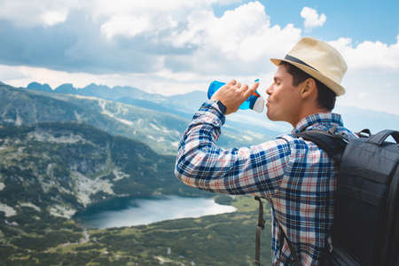 Traveler drinks water in the mountains