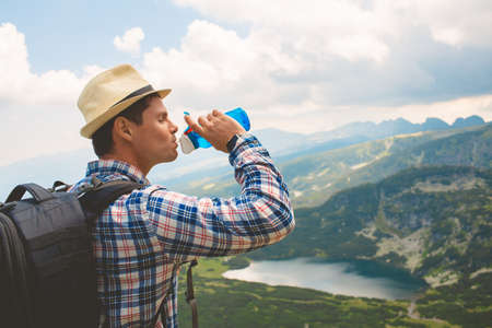 Traveler drinks water in the mountainsの写真素材