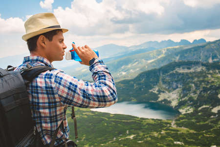 Traveler drinks water in the mountainsの写真素材
