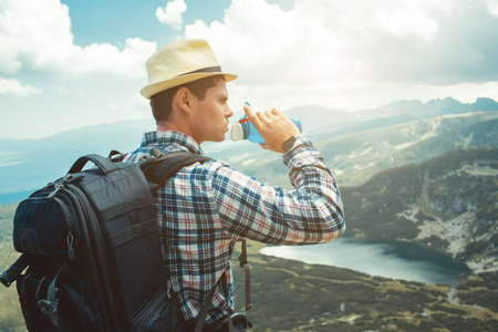 Traveler drinks water in the mountainsの写真素材