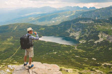 Traveler drinks water in the mountains