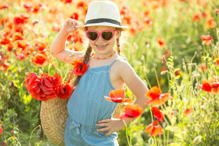 Little girl posing in a poppiesの写真素材
