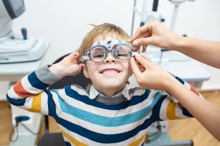 Diagnostic cabinet A cute little boy is diagnosed with vision and contact lenses are selected.