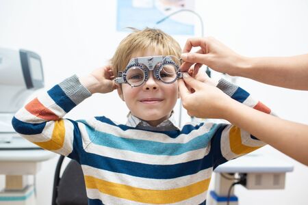 Diagnostic cabinet A cute little boy is diagnosed with vision and contact lenses are selected.