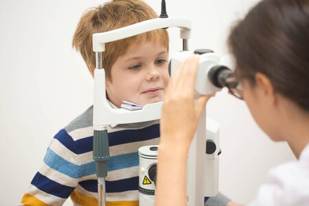 Diagnostic cabinet A cute little boy is diagnosed with vision and contact lenses are selected.の写真素材