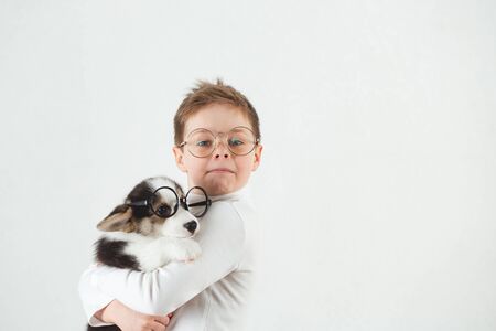Teen boy and Corgi puppy with glassesの写真素材