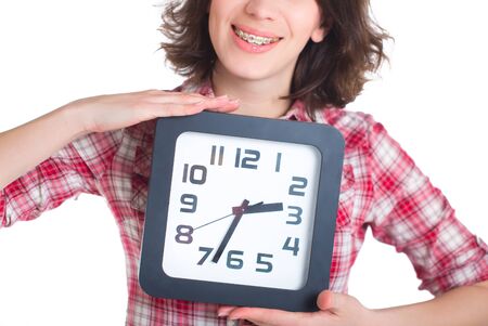 Girl in a plaid shirt with multi-colored braces holding a watchの写真素材