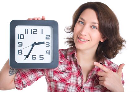Girl in a plaid shirt with multi-colored braces holding a watchの写真素材