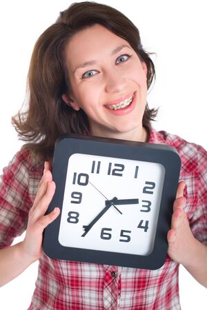 Girl in a plaid shirt with multi-colored braces holding a watchの写真素材