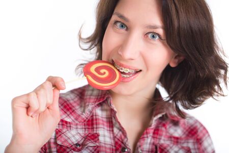 Close-up shot of girl with multicolored bracket systems and lollipopの写真素材