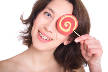 Close-up shot of girl with multicolored bracket systems and lollipopの写真素材