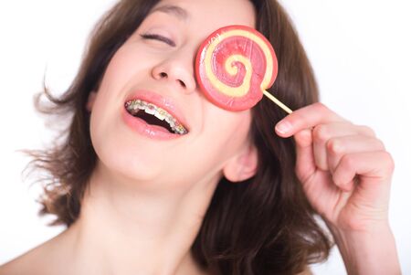 Close-up shot of girl with multicolored bracket systems and lollipopの写真素材