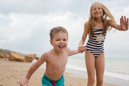 Brother and sisters are playing with sand on the beach. Lifestyle photoの写真素材