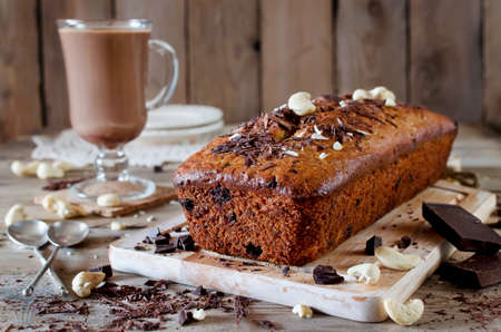 Banana cupcake with chocolate and cashew nut. On the wooden table cupcake and chocolate drinkの写真素材