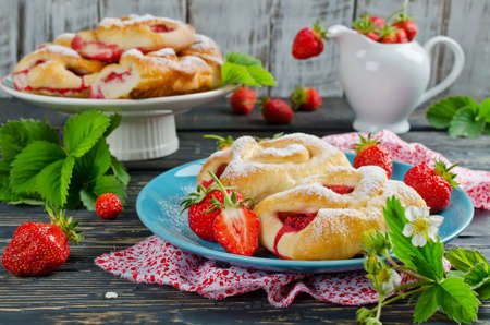 Buns with strawberries on wooden tableの写真素材