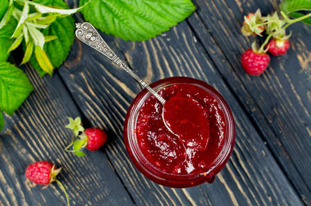 Raspberry jam ( marmalade ) and fresh raspberry on a rustic wooden table.Selective focusの写真素材