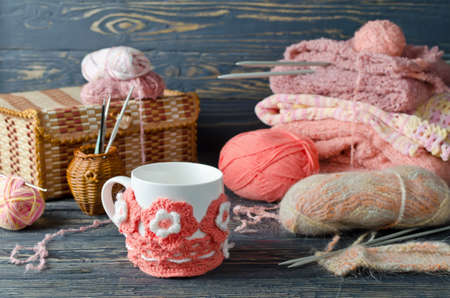 Pink yarn and craft items on a wooden table