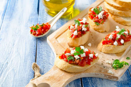 Italian bruschetta with chopped tomatoes and cheese on grilled crusty breadの写真素材