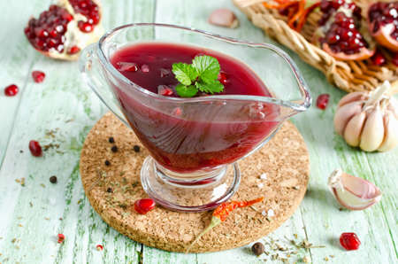 Fresh pomegranate sauce for meat on a wooden table. Sauce made from red wine and pomegranate juiceの写真素材